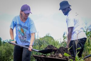 Vereinsmitglied von Generation Restoration arbeitet zusammen mit MANUD-Gründer Fazil im Permagarten