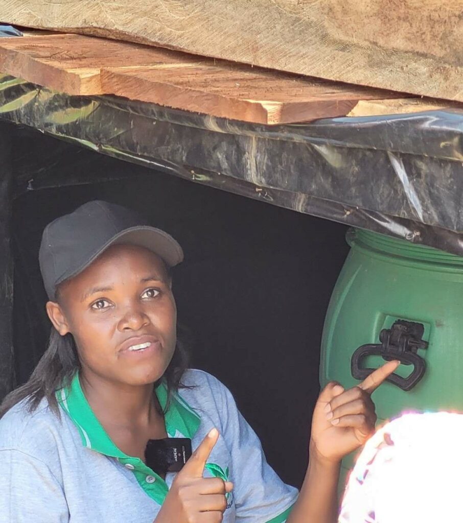 Winnie Tushabe, YICE co-founder and implementation director in front of compost toilet Ecosan
