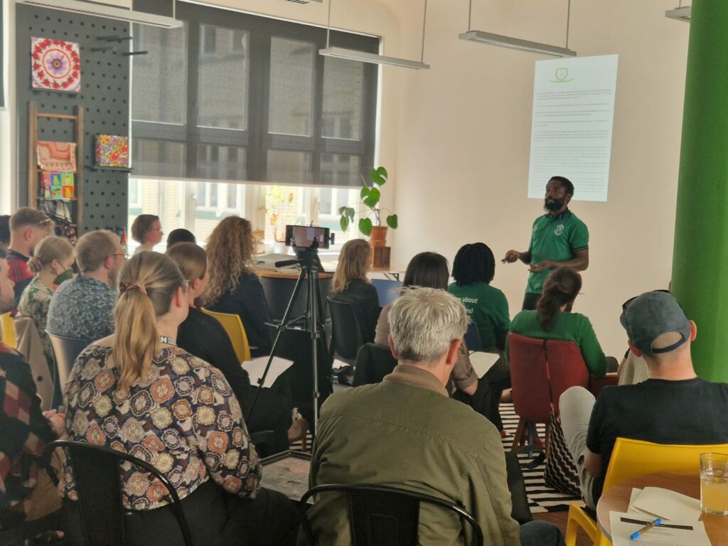 Bemeriki Bisimwa Dusabe gives a talk to an audience for Tina Teucher's initiative Generation Restoration in Berlin