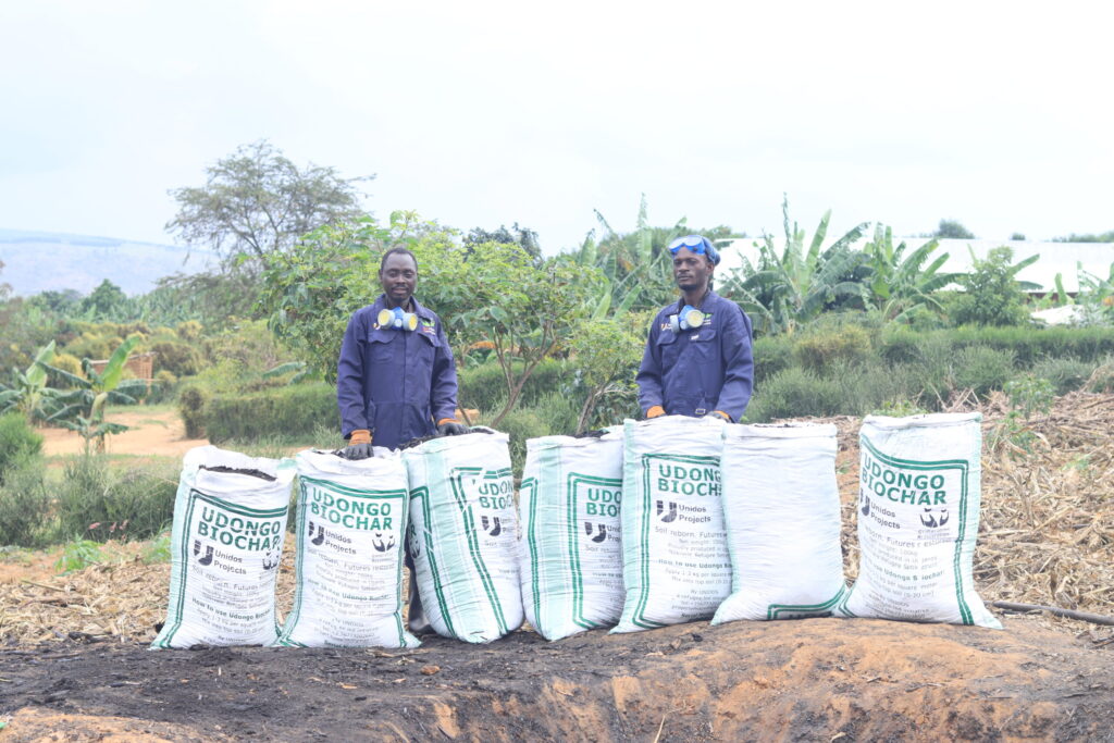UNIDOS staff with bags full of biochar (high-quality charcoal)